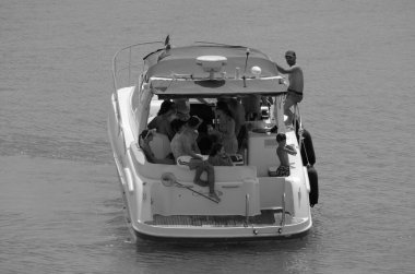 İtalya, Sicilya, Akdeniz, Marina di Ragusa (Ragusa Eyaleti); 28 Temmuz 2024, limanda lüks bir yatta insanlar - EDITORIAL