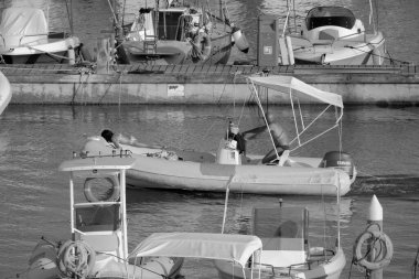 İtalya, Sicilya, Akdeniz, Marina di Ragusa (Ragusa Eyaleti); 28 Temmuz 2024, limanda kauçuk bir tekne ve lüks yatlarda bir çift - EDITORIAL