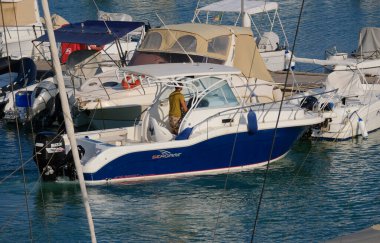 İtalya, Sicilya, Akdeniz, Marina di Ragusa (Ragusa Eyaleti); 29 Temmuz 2024, limandaki bir motorlu teknede adam - EDITORIAL