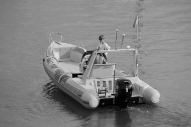 İtalya, Sicilya, Akdeniz, Marina di Ragusa (Ragusa Eyaleti); 30 Temmuz 2024, limanda kauçuk bir tekne ve lüks yatlarda bir çift - EDITORIAL