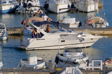 İtalya, Sicilya, Akdeniz, Marina di Ragusa (Ragusa ili); 31 Temmuz 2024, limanda lüks bir yatta erkekler - EDITORIAL