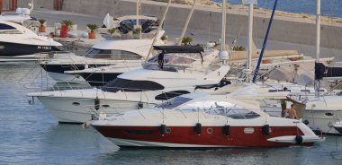 İtalya, Sicilya, Akdeniz, Marina di Ragusa (Ragusa Eyaleti); 3 Ağustos 2024, limandaki lüks yatlarda yaşayan insanlar - EDITORIAL