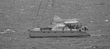 İtalya, Sicilya, Akdeniz, Marina di Ragusa (Ragusa Eyaleti); 5 Ağustos 2024, insanlar Sicilya Kanalı 'nda katamaran yelkenliyle seyahat ediyorlar - EDITORIAL