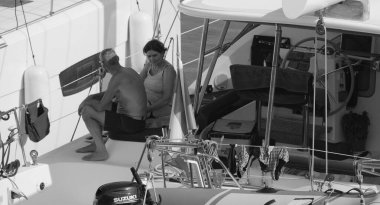 İtalya, Sicilya, Akdeniz, Marina di Ragusa (Ragusa Eyaleti); 5 Ağustos 2024, limanda bir katamaran yelkenli teknesinde çift