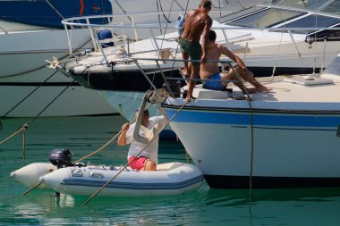 İtalya, Sicilya, Akdeniz, Marina di Ragusa (Ragusa ili); 6 Ağustos 2024, limandaki insanlar ve lüks yatlar - EDITORIAL