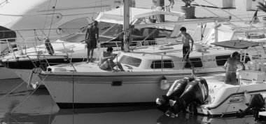 İtalya, Sicilya, Akdeniz, Marina di Ragusa (Ragusa ili); 6 Ağustos 2024, limandaki lüks yatlarda erkekler - EDITORIAL