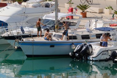 İtalya, Sicilya, Akdeniz, Marina di Ragusa (Ragusa ili); 6 Ağustos 2024, limandaki lüks yatlarda erkekler - EDITORIAL