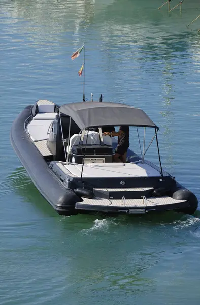 İtalya, Sicilya, Akdeniz, Marina di Ragusa (Ragusa Eyaleti), limandaki büyük kauçuk bir teknede erkekler 
