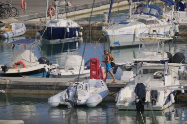 İtalya, Sicilya, Akdeniz, Marina di Ragusa (Ragusa ili); 8 Ağustos 2024, limandaki insanlar, motorlu tekneler ve lüks yatlar - EDITORIAL