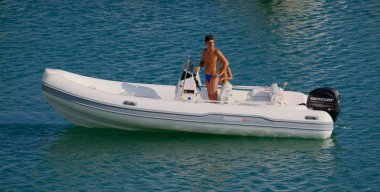 İtalya, Sicilya, Akdeniz, Marina di Ragusa (Ragusa ili); 8 Ağustos 2024, limandaki kauçuk bir teknede insanlar - EDITORIAL