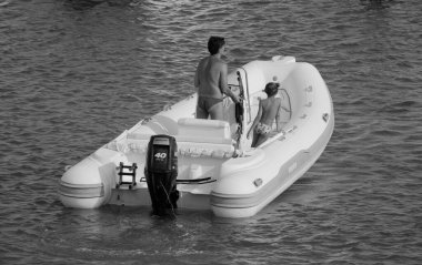 İtalya, Sicilya, Akdeniz, Marina di Ragusa (Ragusa ili); 8 Ağustos 2024, limandaki kauçuk bir teknede insanlar - EDITORIAL