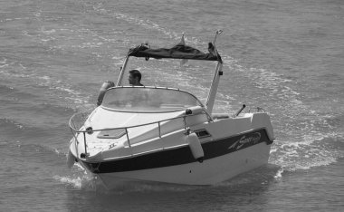 İtalya, Sicilya, Akdeniz, Marina di Ragusa (Ragusa Eyaleti); 9 Ağustos 2024, limandaki bir motorlu teknede adam - EDITORIAL