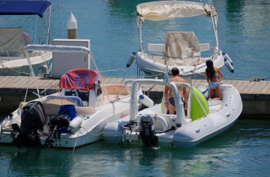 İtalya, Sicilya, Akdeniz, Marina di Ragusa (Ragusa ili); 9 Ağustos 2024, limandaki kauçuk bir teknede insanlar - EDITORIAL