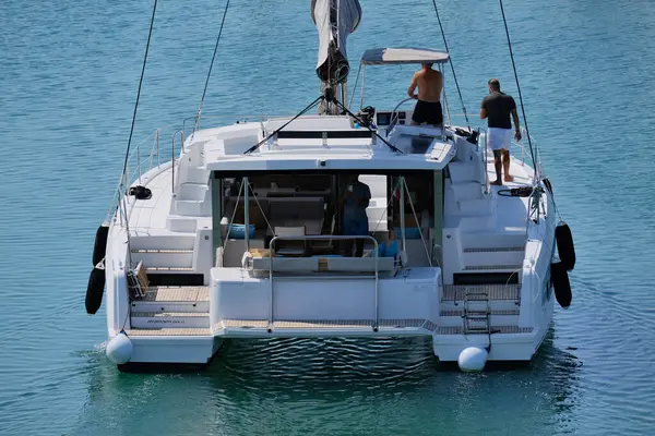 İtalya, Sicilya, Akdeniz, Marina di Ragusa (Ragusa ili); 10 Ağustos 2024, limandaki katamaran yelkenli teknesinde erkekler - EDITORIAL