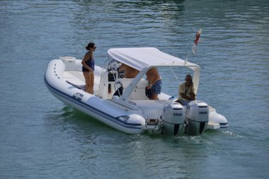 İtalya, Sicilya, Akdeniz, Marina di Ragusa (Ragusa ili); 10 Ağustos 2024, limandaki bir kauçuk teknede insanlar - EDITORIAL
