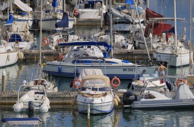 İtalya, Sicilya, Akdeniz, Marina di Ragusa (Ragusa ili); 12 Ağustos 2024, limandaki insanlar, motorlu tekneler ve lüks yatlar - EDITORIAL