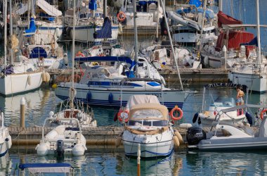 İtalya, Sicilya, Akdeniz, Marina di Ragusa (Ragusa ili); 12 Ağustos 2024, limandaki insanlar, motorlu tekneler ve lüks yatlar - EDITORIAL