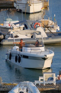 İtalya, Sicilya, Akdeniz, Marina di Ragusa (Ragusa ili); 12 Ağustos 2024, limanda lüks bir yatta çift - EDITORIAL