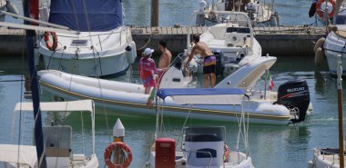 İtalya, Sicilya, Akdeniz, Marina di Ragusa (Ragusa ili); 16 Ağustos 2024, limandaki kauçuk bir teknede insanlar - EDITORIAL