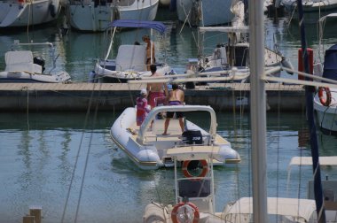 İtalya, Sicilya, Akdeniz, Marina di Ragusa (Ragusa ili); 16 Ağustos 2024, limandaki kauçuk bir teknede insanlar - EDITORIAL