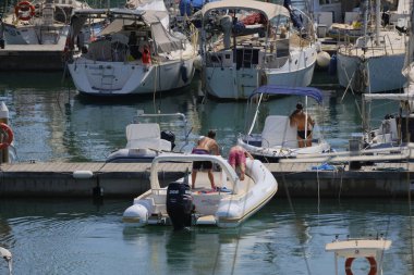 İtalya, Sicilya, Akdeniz, Marina di Ragusa (Ragusa ili); 16 Ağustos 2024, limandaki kauçuk bir teknede insanlar - EDITORIAL