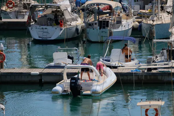 İtalya, Sicilya, Akdeniz, Marina di Ragusa (Ragusa ili); 16 Ağustos 2024, limandaki kauçuk bir teknede insanlar - EDITORIAL