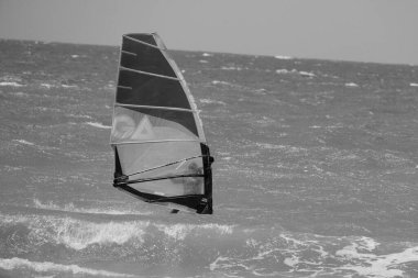 İtalya, Sicilya, Akdeniz, Donnalucata (Ragusa Eyaleti); 20 Ağustos 2024, dalgalara binen sörfçü - EDITORIAL