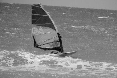 İtalya, Sicilya, Akdeniz, Donnalucata (Ragusa Eyaleti); 20 Ağustos 2024, dalgalara binen sörfçü - EDITORIAL