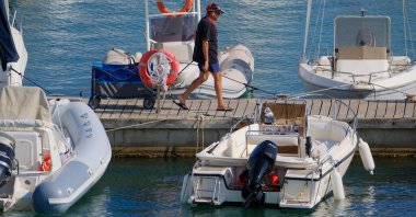 İtalya, Sicilya, Akdeniz, Marina di Ragusa (Ragusa ili); 22 Ağustos 2024, limandaki insanlar, motorlu tekneler ve lüks yatlar - EDITORIAL