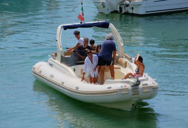 İtalya, Sicilya, Akdeniz, Marina di Ragusa (Ragusa ili); 23 Ağustos 2024, limandaki kauçuk bir teknede insanlar - EDITORIAL