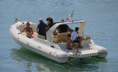İtalya, Sicilya, Akdeniz, Marina di Ragusa (Ragusa ili); 23 Ağustos 2024, limandaki kauçuk bir teknede insanlar - EDITORIAL