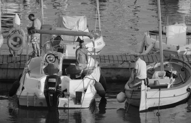 İtalya, Sicilya, Akdeniz, Marina di Ragusa (Ragusa ili); 23 Ağustos 2024, limandaki insanlar, motorlu tekneler ve lüks yatlar - EDITORIAL