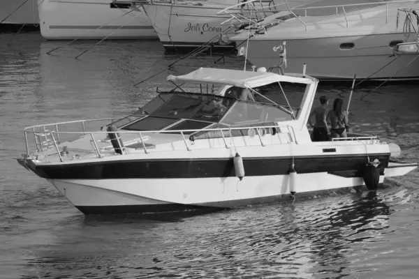 İtalya, Sicilya, Akdeniz, Marina di Ragusa (Ragusa Eyaleti); 23 Ağustos 2024, limanda lüks bir yatta insanlar - EDITORIAL