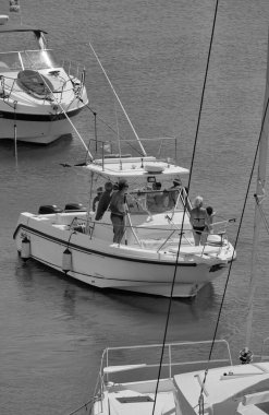 İtalya, Sicilya, Akdeniz, Marina di Ragusa (Ragusa Eyaleti); 24 Ağustos 2024, limandaki bir balıkçı teknesindeki insanlar - EDITORIAL