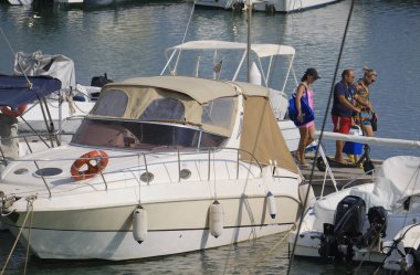 İtalya, Sicilya, Akdeniz, Marina di Ragusa (Ragusa ili); 25 Ağustos 2024, limandaki insanlar, motorlu tekneler ve lüks yatlar - EDITORIAL