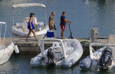 İtalya, Sicilya, Akdeniz, Marina di Ragusa (Ragusa ili); 25 Ağustos 2024, limandaki insanlar, motorlu tekneler ve lüks yatlar - EDITORIAL