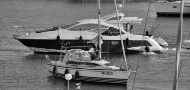 İtalya, Sicilya, Akdeniz, Marina di Ragusa (Ragusa Eyaleti); 25 Ağustos 2024, limandaki lüks yatlarda yaşayan insanlar - EDITORIAL