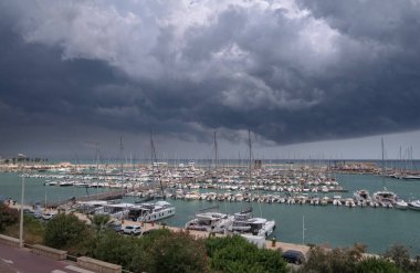 İtalya, Sicilya, Akdeniz, Marina di Ragusa (Ragusa Eyaleti); bulutlu bir günde limanda motorlu tekne ve lüks yatlar