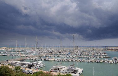 İtalya, Sicilya, Akdeniz, Marina di Ragusa (Ragusa Eyaleti); bulutlu bir günde limanda motorlu tekne ve lüks yatlar