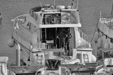 İtalya, Sicilya, Akdeniz, Marina di Ragusa (Ragusa Eyaleti); 27 Ağustos 2024, limanda lüks bir yatta insanlar - EDITORIAL