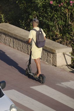 İtalya, Sicilya, Akdeniz, Marina di Ragusa (Ragusa Eyaleti), kasabanın deniz yolundaki bisiklet yolunda bir adam.