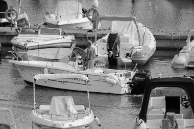 İtalya, Sicilya, Akdeniz, Marina di Ragusa (Ragusa Eyaleti); 19 Eylül 2024, limandaki bir motorlu teknede adam - EDITORIAL