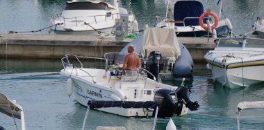 İtalya, Sicilya, Akdeniz, Marina di Ragusa (Ragusa Eyaleti); 19 Eylül 2024, limandaki bir motorlu teknede adam - EDITORIAL