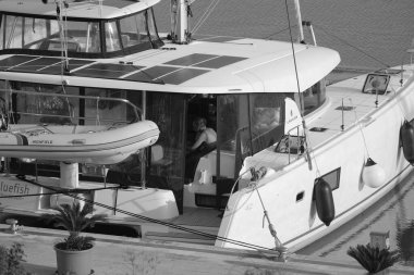 İtalya, Sicilya, Akdeniz, Marina di Ragusa (Ragusa Eyaleti); 19 Eylül 2024, limandaki bir katamaran yelkenli teknesinde adam - EDITORIAL