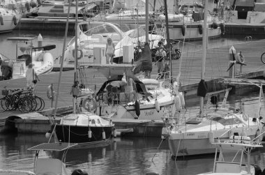 İtalya, Sicilya, Akdeniz, Marina di Ragusa (Ragusa Eyaleti); 21 Eylül 2024, limandaki insanlar, motorlu tekneler ve lüks yatlar - EDITORIAL
