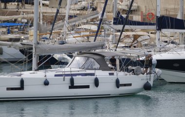 İtalya, Sicilya, Akdeniz, Marina di Ragusa (Ragusa Eyaleti); 22 Eylül 2024, limandaki bir yelkenli ve lüks yatlarda erkekler - EDITORIAL