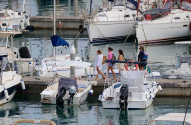 İtalya, Sicilya, Akdeniz, Marina di Ragusa (Ragusa ili); 22 Eylül 2024, limandaki insanlar, motorlu tekneler ve lüks yatlar - EDITORIAL