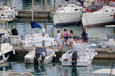 İtalya, Sicilya, Akdeniz, Marina di Ragusa (Ragusa ili); 22 Eylül 2024, limandaki insanlar, motorlu tekneler ve lüks yatlar - EDITORIAL