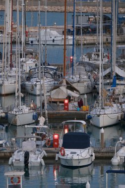 İtalya, Sicilya, Akdeniz, Marina di Ragusa (Ragusa Eyaleti); 22 Eylül 2024, gün batımında limanda motorlu tekne ve lüks yatlar - EDITORIAL