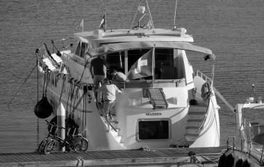 İtalya, Sicilya, Akdeniz, Marina di Ragusa (Ragusa Eyaleti); 1 Ekim 2024, limanda lüks bir yatta erkekler - EDITORIAL